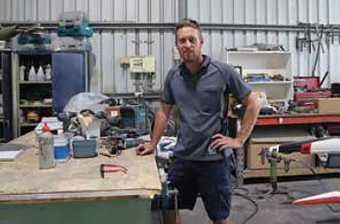 Morgan standing at the workbench in the Morgan Vine Marine workshop